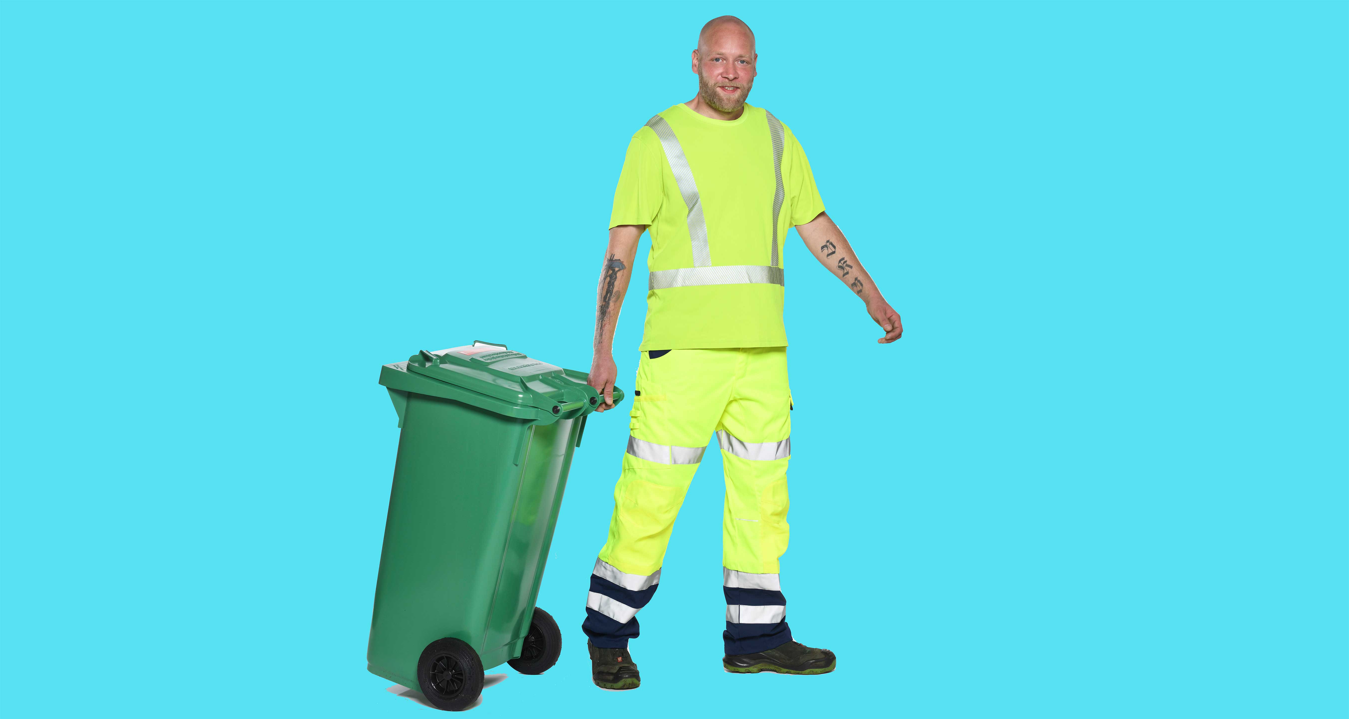 Müllwerker zieht eine grüne Restmülltonne