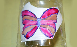 Ausgemalte Schmetterlingsvorlage auf einer Plastikflasche