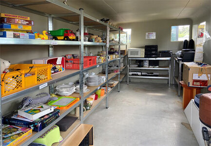 Container als Wechselstube umfunktioniert mit Regalen für nicht mehr benötigte Gebrauchsgegenstände