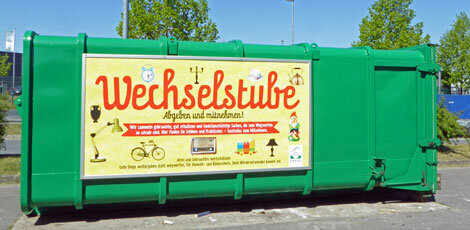 Grüne Container mit gelben Plakat "Wechselstube"