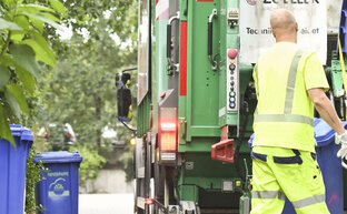 Papierbehälter werden ins Fahrzeug entleert