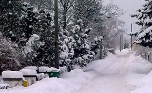 Verschneite Straßen mit Mülltonnen