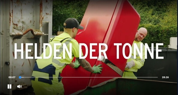 zwei Müllwerker beim Transport eines Kühlschranks