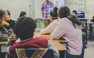 Eine Unterrichtsstunde im Klassenzimmer mit einem Lehrer an der Tafel
