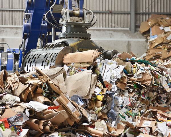 Altpapier wird mit einem Bagger verladen