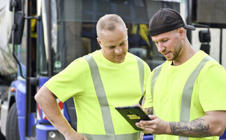 Müllwerker schauen auf ein Tablett